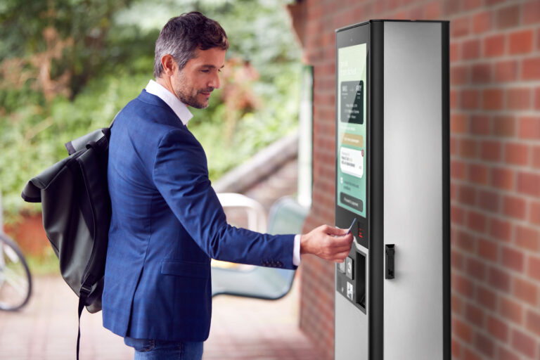 Mann nutz Outdoor für Ticketing an einem Bahnhof